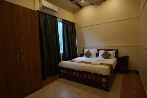a bedroom with a large bed with a window at Hotel Lotus in Candolim