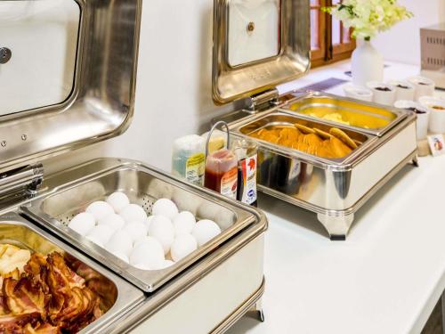 a buffet with eggs and food on a counter at ibis Styles Luzern in Luzern