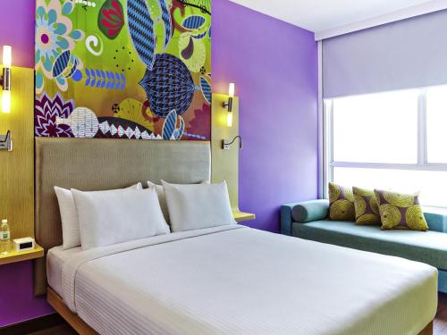 a bedroom with a large bed and a couch at Ibis Styles Kuala Lumpur Fraser Business Park in Kuala Lumpur