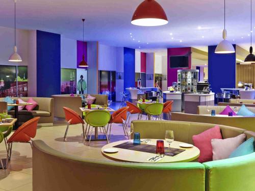 a restaurant with colorful chairs and tables in a cafeteria at Ibis Styles Kuala Lumpur Fraser Business Park in Kuala Lumpur