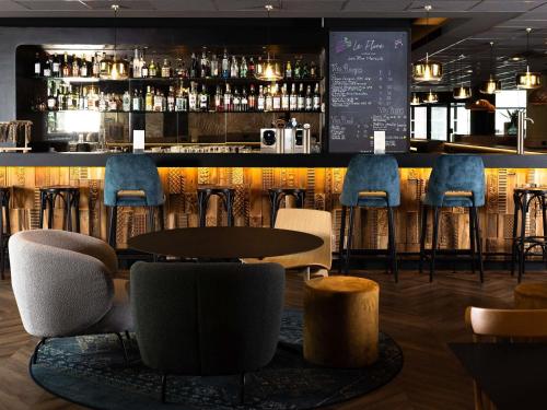 a bar in a restaurant with chairs and a counter at Mercure Valenciennes Centre in Valenciennes