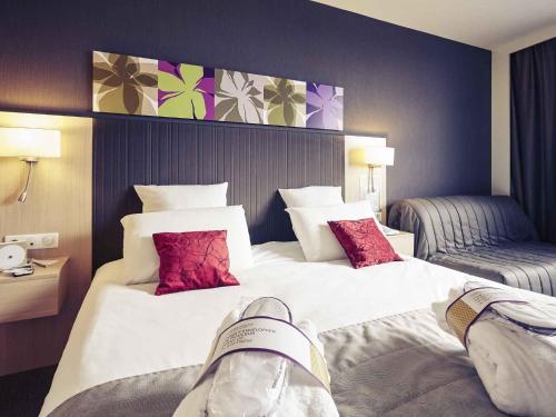 a person laying on a bed in a hotel room at Mercure Valenciennes Centre in Valenciennes