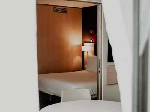 a hotel room with a bed and a mirror at Mercure Valenciennes Centre in Valenciennes
