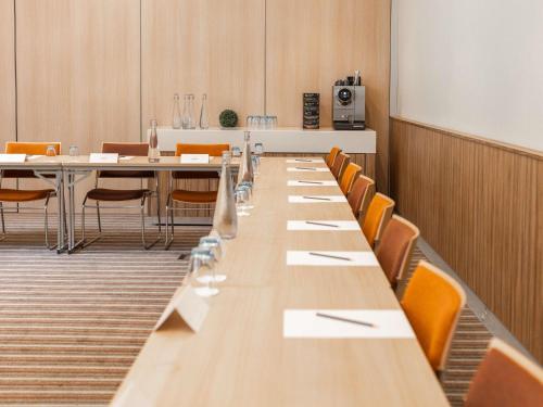 a conference room with a long table and chairs at Mercure Valenciennes Centre in Valenciennes