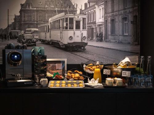 a table with food on a street with a trolley at Mercure Valenciennes Centre in Valenciennes