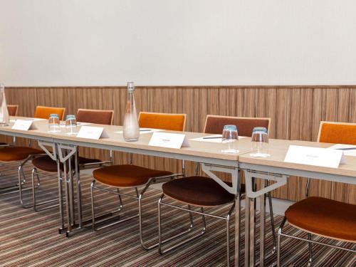 a conference room with a long table and chairs at Mercure Valenciennes Centre in Valenciennes
