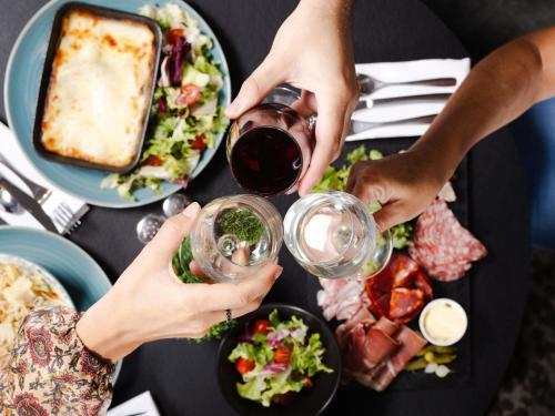 a group of people drinking wine at a table with food at Mercure Valenciennes Centre in Valenciennes