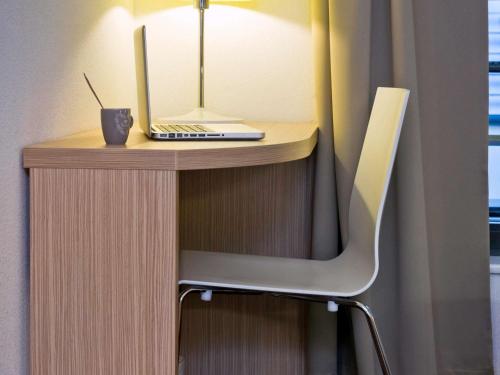 a desk with a laptop computer on top of it at Aparthotel Adagio Access Bruxelles Europe Aparthotel in Brussels