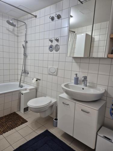 a white bathroom with a sink and a toilet at Luxury Penthouse 15 Min to Wiesn with Parking, Balcony in Munich