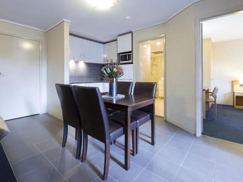 a kitchen and dining room with a table and chairs at ibis Styles Canberra in Canberra