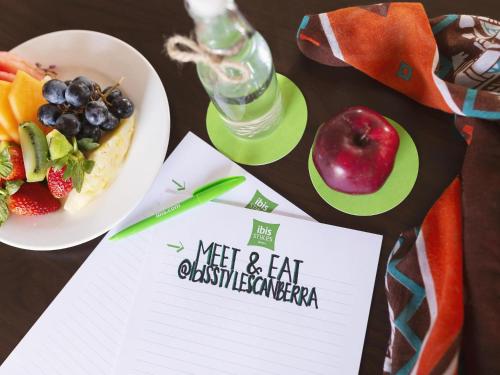 a table with a plate of food and a plate of fruit at ibis Styles Canberra in Canberra
