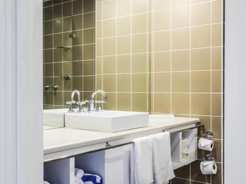 a bathroom with a sink and a mirror at Mercure Gerringong Resort in Gerringong