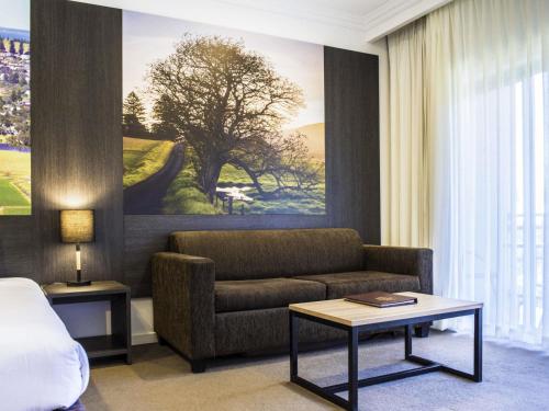 a hotel room with a couch and a bed at Mercure Gerringong Resort in Gerringong