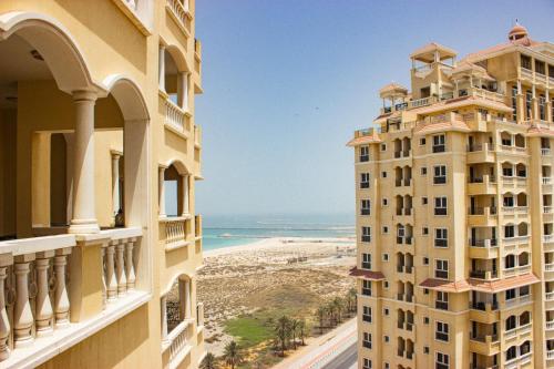 a view of the beach from the balcony of a building at Royal Breeze Sea View One Bedroom Apartment in Ras al Khaimah