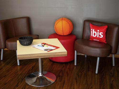 a room with a table and a basketball on a stool at Ibis Kaunas Centre in Kaunas