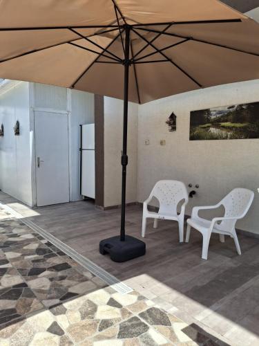 two chairs and a table under an umbrella at דובדבן בגולן in Had Nes