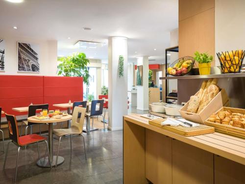 a restaurant with a table and chairs and a counter at ibis Paris Gare de Lyon Reuilly in Paris