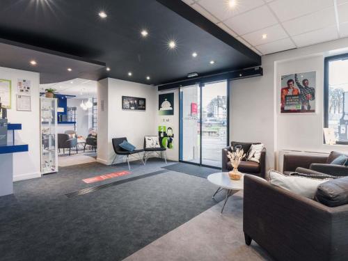 a living room with two couches and a table at ibis Styles Vannes Gare Centre in Vannes