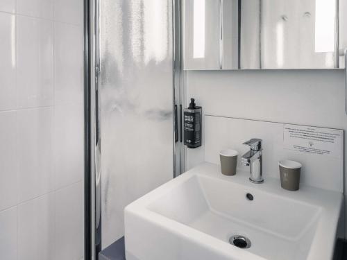 a bathroom with a white sink and a shower at ibis Styles Vannes Gare Centre in Vannes