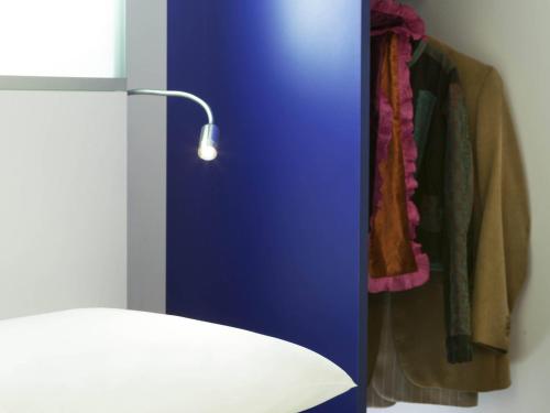 a closet with coats hanging on a wall at ibis Styles Vannes Gare Centre in Vannes