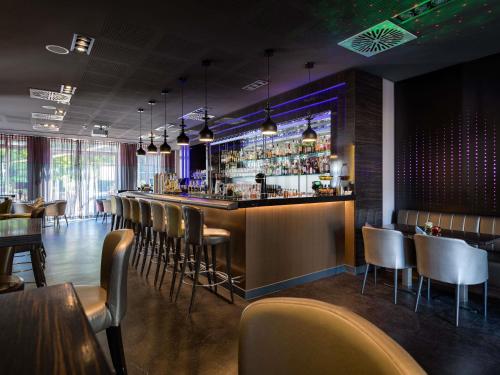 a bar with a row of chairs in a restaurant at Pullman Munich in Munich