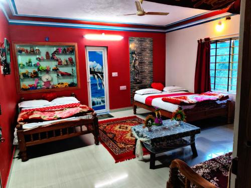 two beds in a room with red walls at Zawa Home stay,coorg in Madikeri