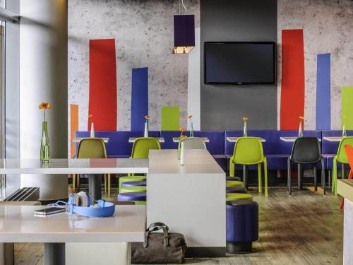 a conference room with tables and chairs and a tv at Ibis budget München Airport Erding in Erding
