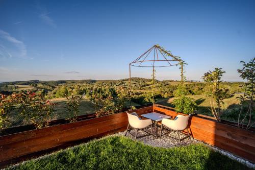 a patio with a table and chairs and a view at Casa Deluxe in Sinteu - intersectia intre modern si linistea naturii in Şinteu