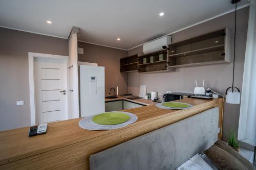 a kitchen with a counter with green plates on it at Casa Deluxe in Sinteu - intersectia intre modern si linistea naturii in Şinteu