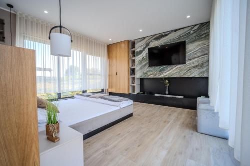 a bedroom with a large bed and a flat screen tv at Casa Deluxe in Sinteu - intersectia intre modern si linistea naturii in Şinteu