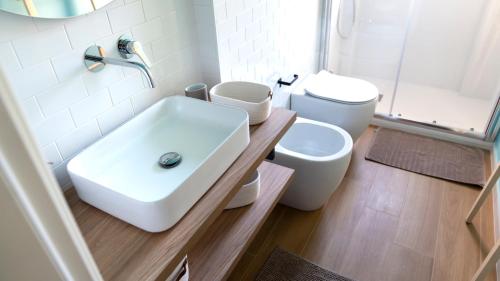 a bathroom with a white sink and a toilet at Zagara di Arancio e Limone Guesthouse in Cassibile