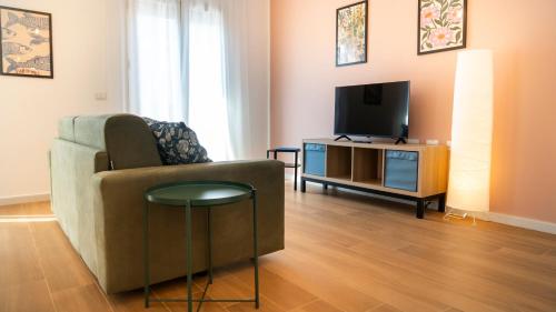 a living room with a couch and a television at Zagara di Arancio e Limone Guesthouse in Cassibile
