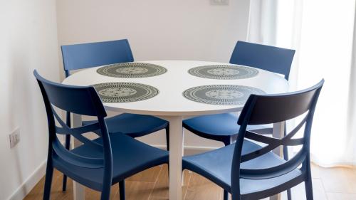 a white table with four blue chairs around it at Zagara di Arancio e Limone Guesthouse in Cassibile
