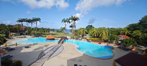 Blick auf den Pool in einem Resort mit Palmen in der Unterkunft Studio Saint Vincent 13 in Sainte-Luce