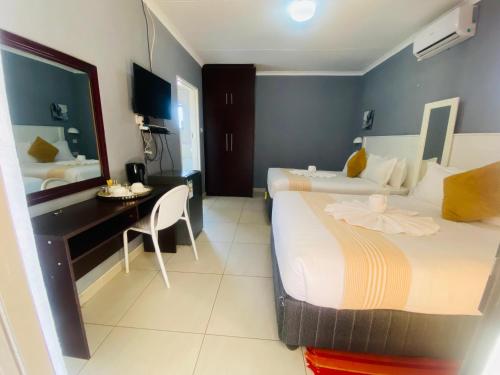 a hotel room with two beds and a desk at Minnestay Guest House in Palatswe