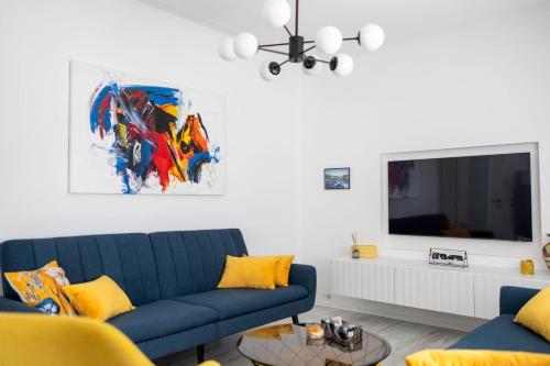a living room with a blue couch and a tv at Una Riverside Heritage House in Bihać