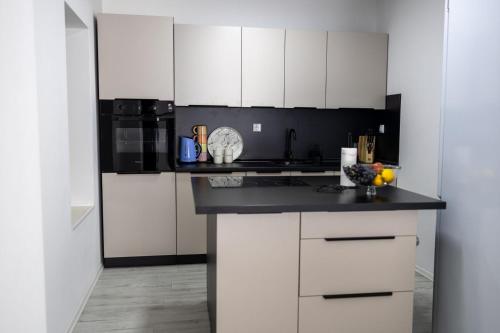 une cuisine avec des armoires blanches et un comptoir noir dans l'établissement Una Riverside Heritage House, à Bihać