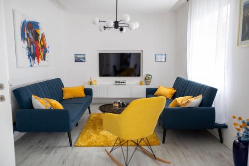 - un salon avec deux canapés bleus et une chaise jaune dans l'établissement Una Riverside Heritage House, à Bihać