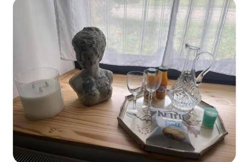 a table with a statue and wine glasses on it at Maison 1838 