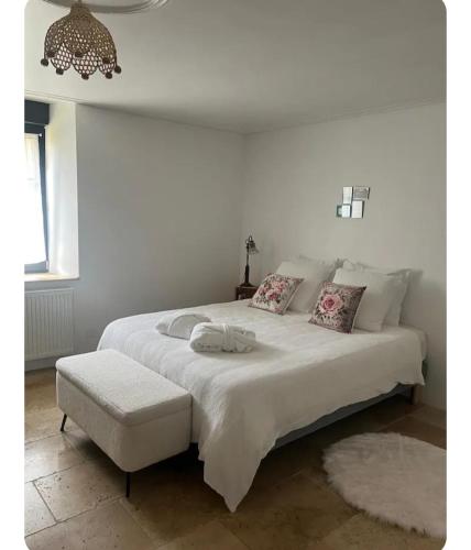 a bedroom with a large white bed with a stool at Maison 1838 