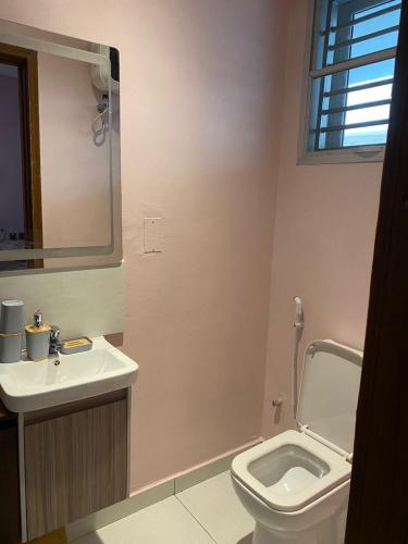 a bathroom with a toilet and a sink and a mirror at Exclusive ANSO HOMES GRA Ikeja in Ikeja