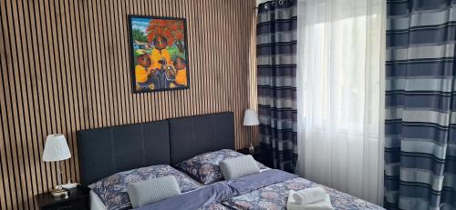 a bedroom with a bed and a picture on the wall at Filsdeger Ház - Central Rooms & Apartmans in Eger
