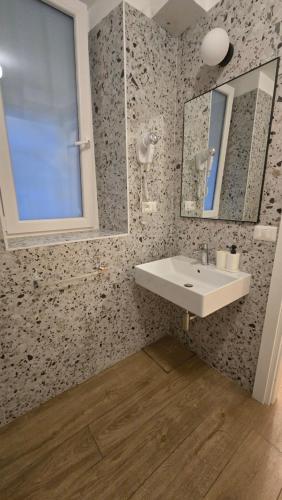 een badkamer met een wastafel en een spiegel bij Domus Regis Rooms & Apartment in Rome