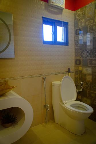 a bathroom with a toilet and a window at Premier Inn Grand Gulberg Lahore in Lahore
