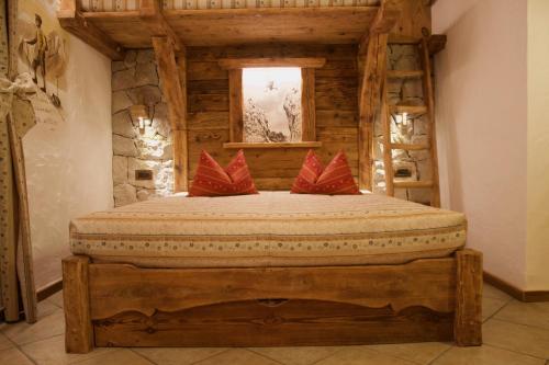 a bedroom with a bed with red pillows on it at Residence Lastè in Moena
