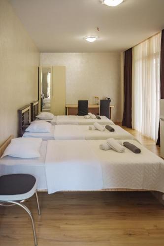 a group of four beds in a room at Hotel Lile • სასტუმრო ლილე in Khulo