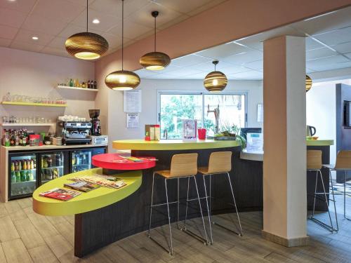 a kitchen with a counter with stools and a bar at ibis styles Dax Centre in Dax