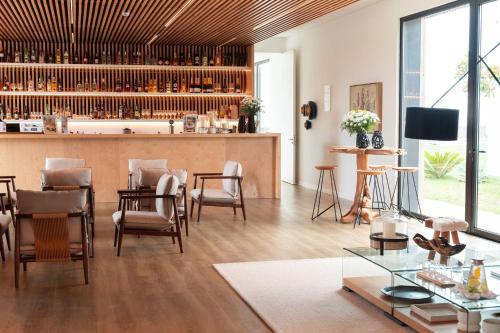 a living room with a bar with chairs and tables at Lusitano Garden Villas in Ponta Delgada