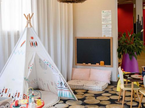a childs play room with a teepee tent at ibis styles Dax Centre in Dax