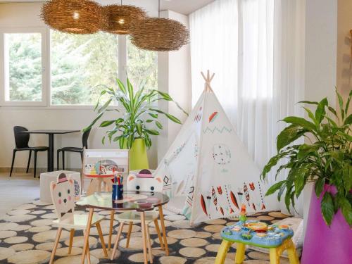 a living room with a table and a play tent at ibis styles Dax Centre in Dax